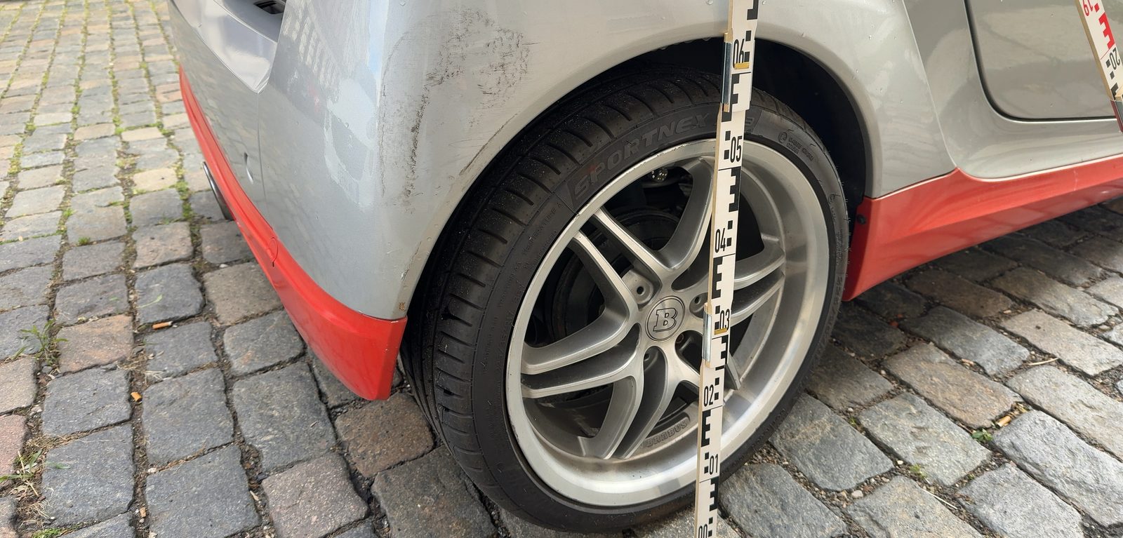 Schürfspuren am hinteren Kotflügel über dem Radlauf, mit Maßstab dokumentiert, Foto aus der Besichtigung